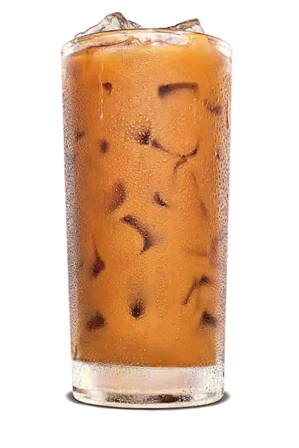 A glass that is filled with ice cubes and iced coffee.