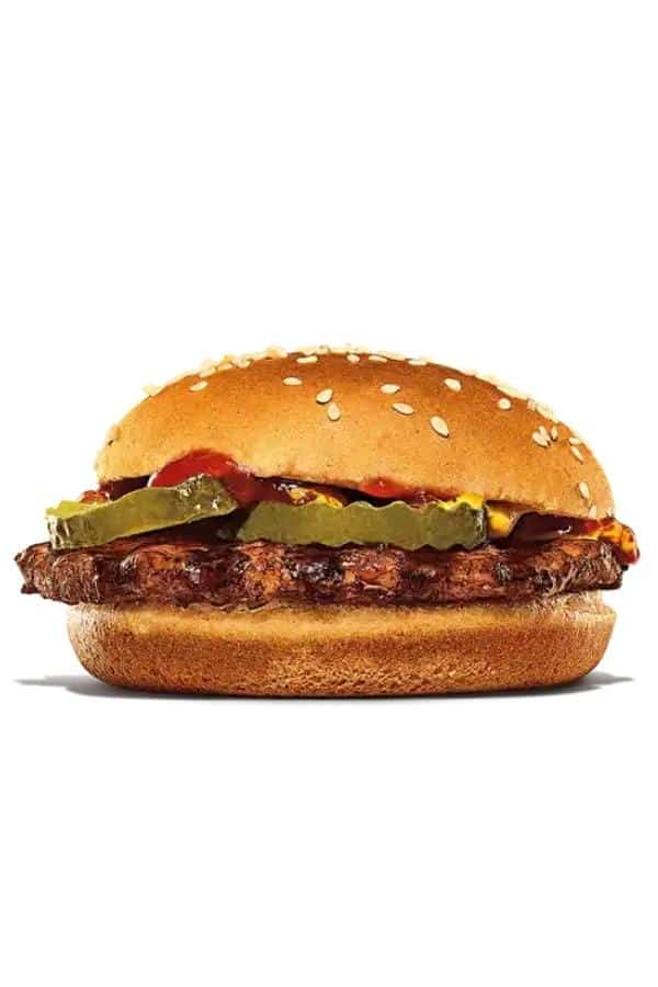 A hamburger with pickles, mustard, and kethcup on it.