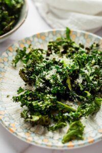 Kale chips spread out on a plate.