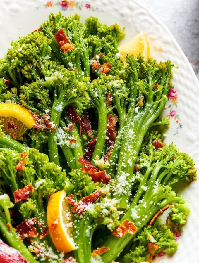 A bunch of broccolini on part of a white plate.