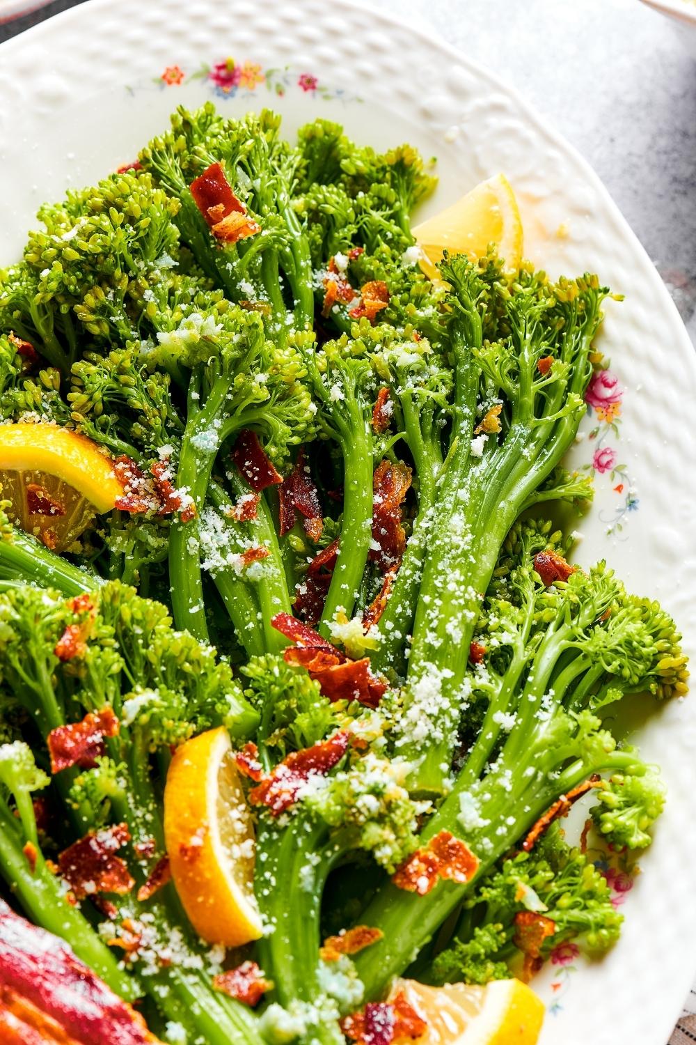 A bunch of broccolini on part of a white plate.