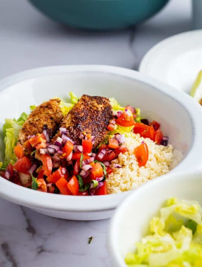 Chicken, pico, cauliflower rice, and lettuce in a bowl.