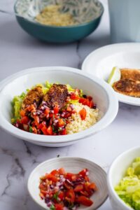 Chicken, pico, cauliflower rice, and lettuce in a bowl. In front of that is a bowl of pico de gallo.