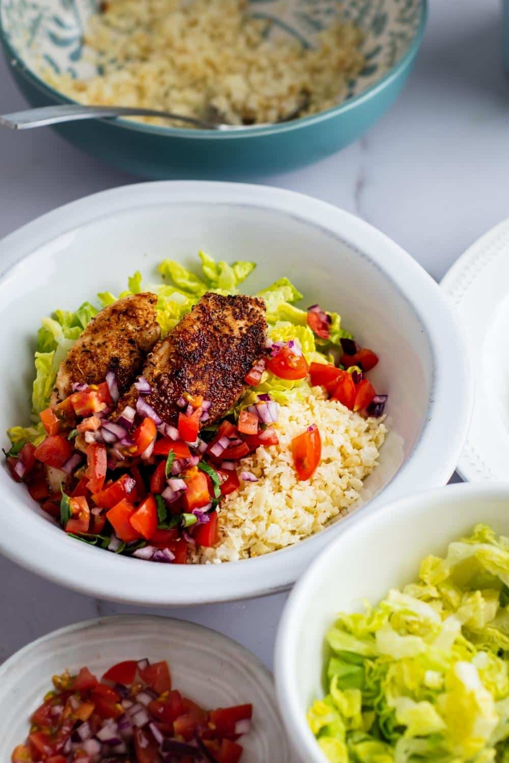 A chipolte keto bowl with pico de gallo, cauliflower rice, and chicken.