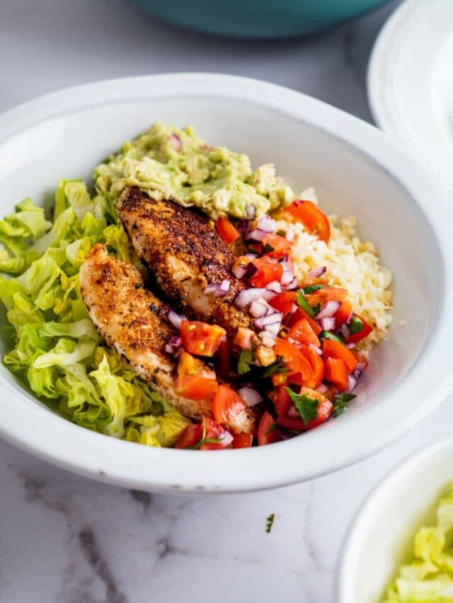 Chicken breasts, pico, lettuce, guac, and cauliflower rice in a bowl.