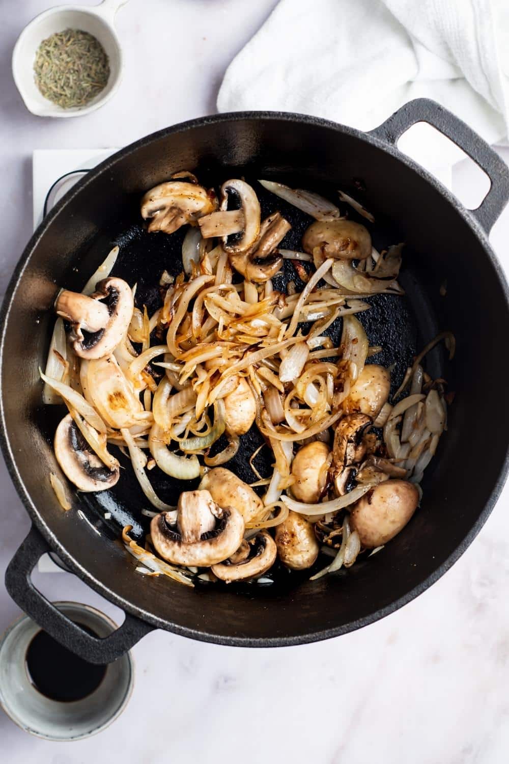 Mushrooms and onions cooking in a Dutch oven.