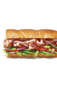Half of a ham sub with red onion, tomato, cucumber, and lettuce.