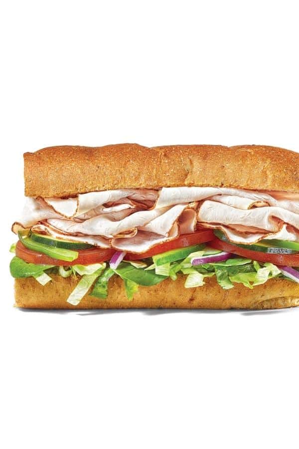 Half of a turkey sub with lettuce, tomato, cucumber, and red onion.