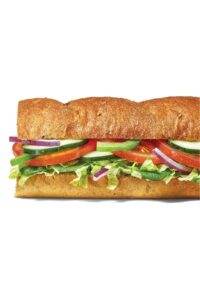 Half of a sub with tomatoes, green and red onion, cucumber, and lettuce.