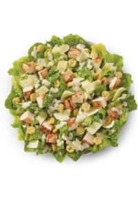 A caesar salad with croutons and parmesan cheese slices.