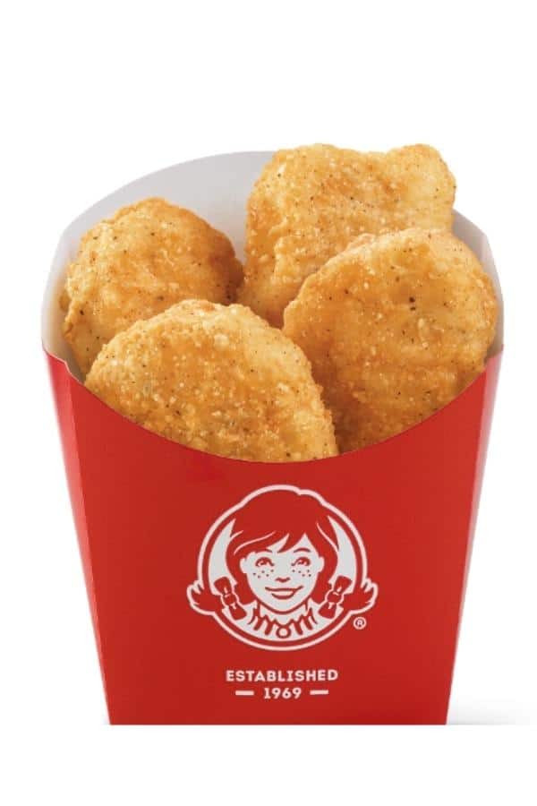 Four chicken nuggets in a Wendy's red container.