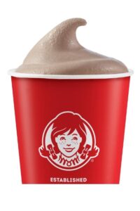 A wendy's chocolate frosty in part of a red cup.