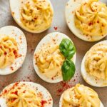 A bunch of southern deviled eggs on part of a plate.