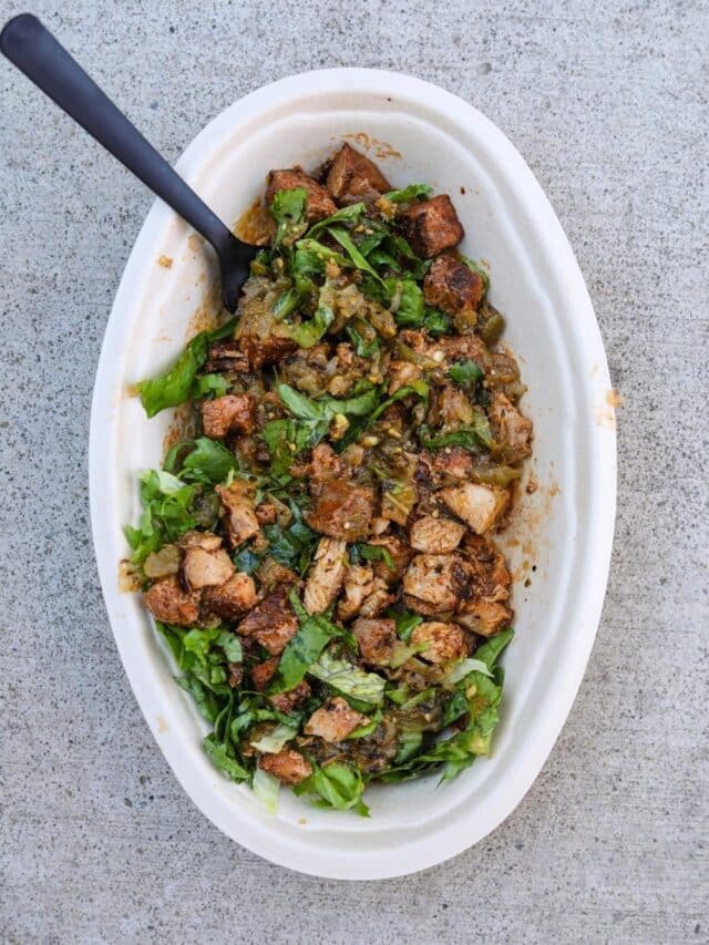 Chicken, green salsa, and shredded lettuce in an oval white bowl.