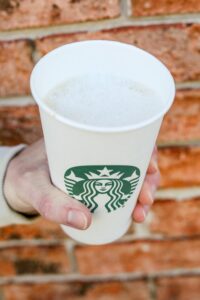 A hand holding a cup of Starbucks keto cappuccino.