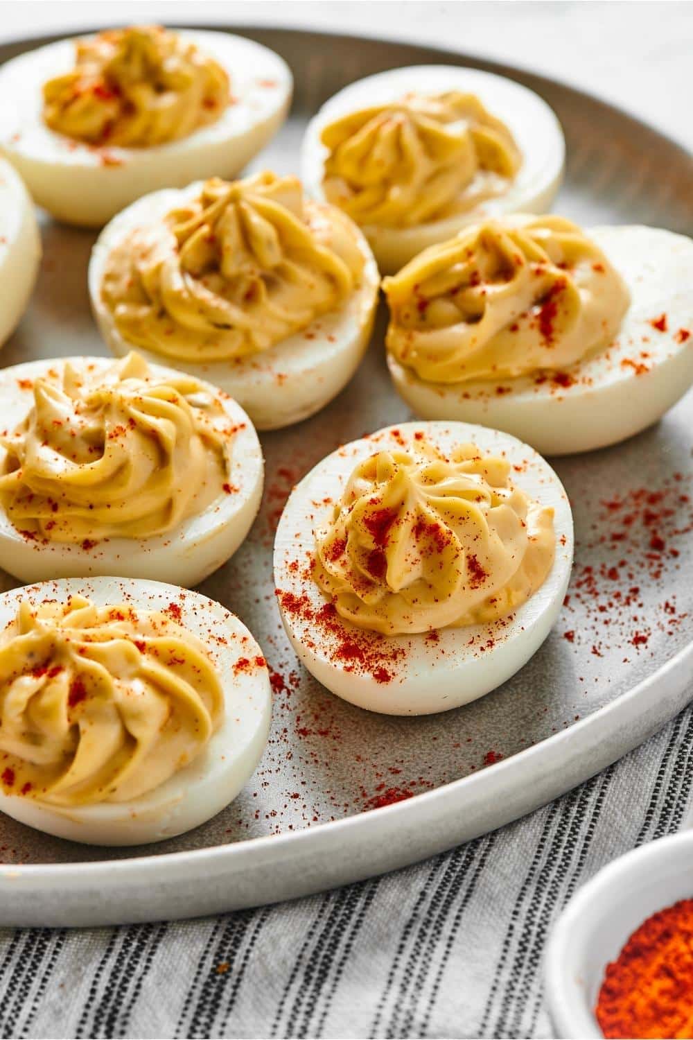 Six hard boiled eggs on a grey plate.