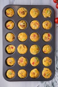 A mini muffin tray that is filled with cooked egg bites.