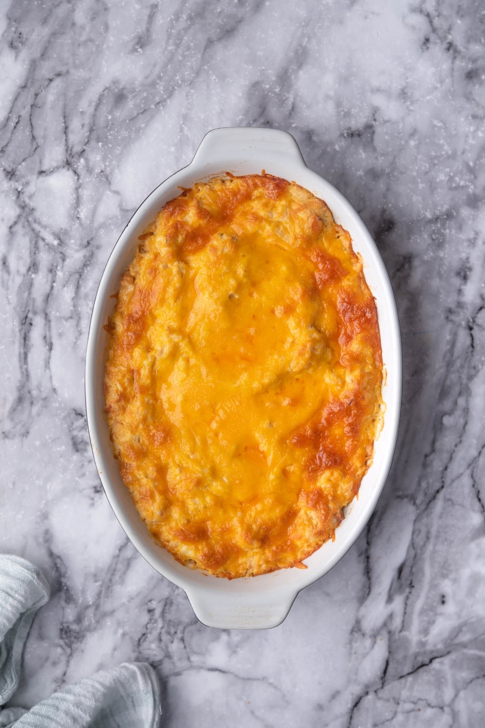 Golden and bubbly melted cheddar cheese in a baking dish.