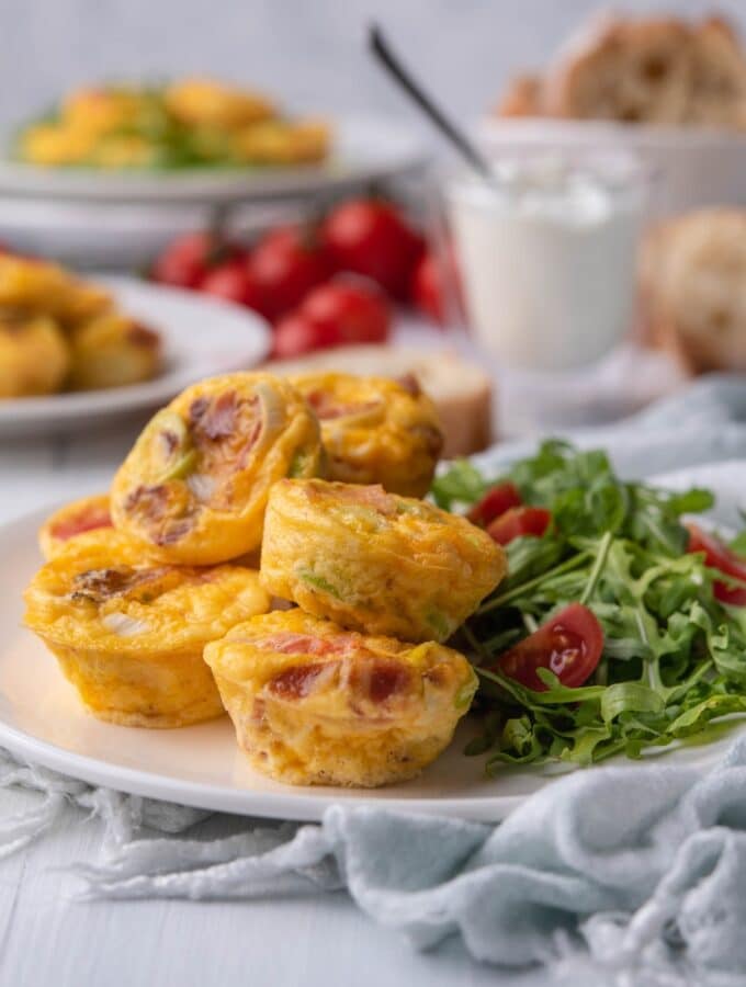 A couple of egg bites on a white plate and stacked on each other.