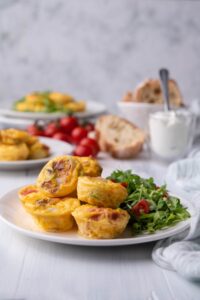 A few egg bites and arugula on a white plate.