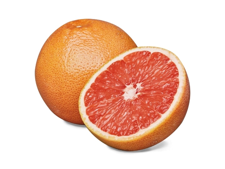 A half of a a grapefruit with a whole grapefruit behind it.