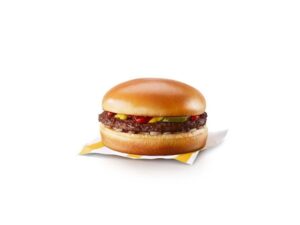 A McDonalds hamburger that has pickle, ketchup, and mustard on it.