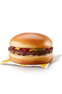 A McDonalds hamburger that has pickle, ketchup, and mustard on it.