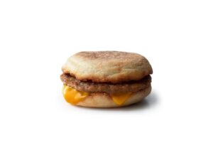 An English muffin with sausage and a slice of American cheese.