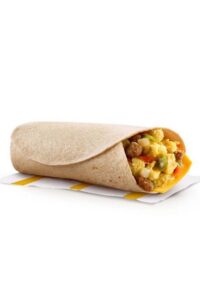 A burrito wrapped with crumbled sausage, egg, and peppers in it.