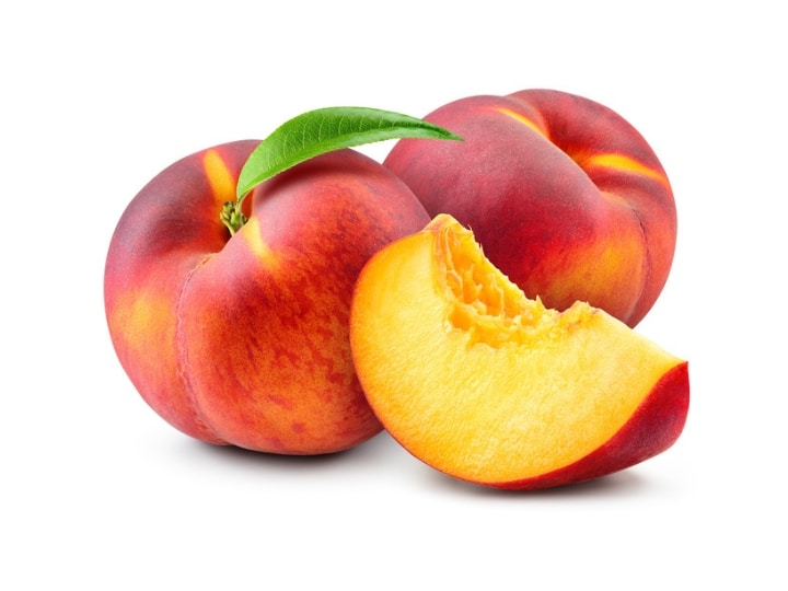 Two whole peaches and a peach slice in front of them.