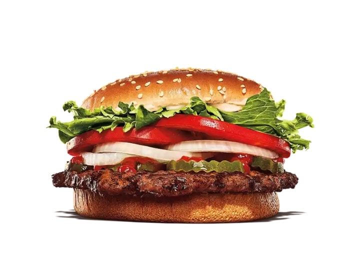 A Burger King whopper with lettuce, onion, tomato, pickles, and ketchup.