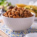 A white bowl filled with seasoned ground turkey.