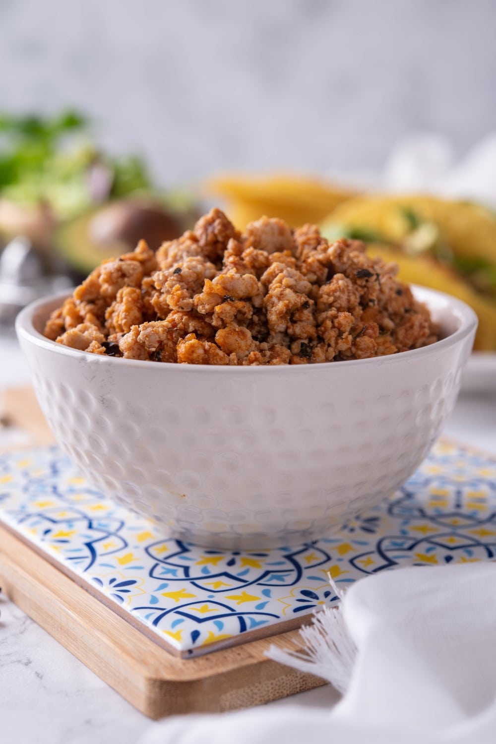 A white bowl filled with seasoned ground turkey.