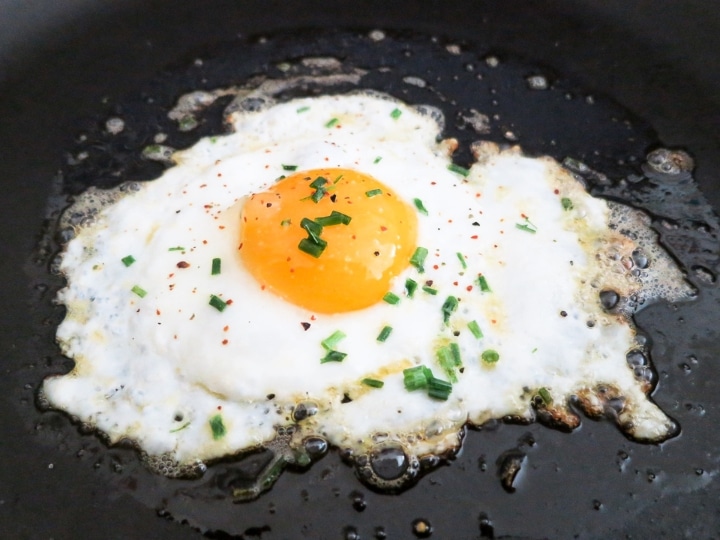 A sunny side up egg cooking in a skillet.