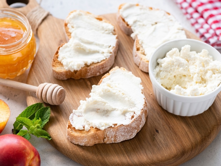 Two sliced of bread with ricotta cheese spread on it.