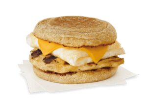 An english muffin with cheese, an egg white, and grilled chicken.