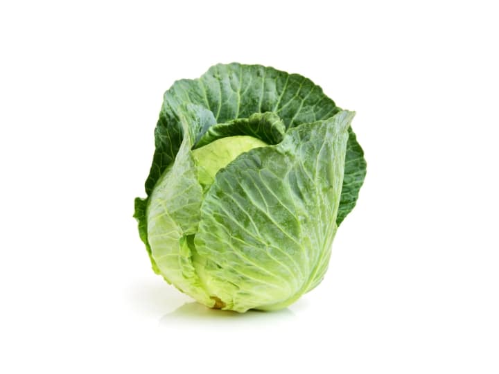 Green cabbage on a white table.
