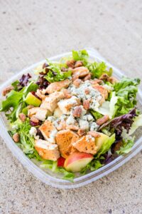 A square container filled with wendy's apple pecan chicken salad,