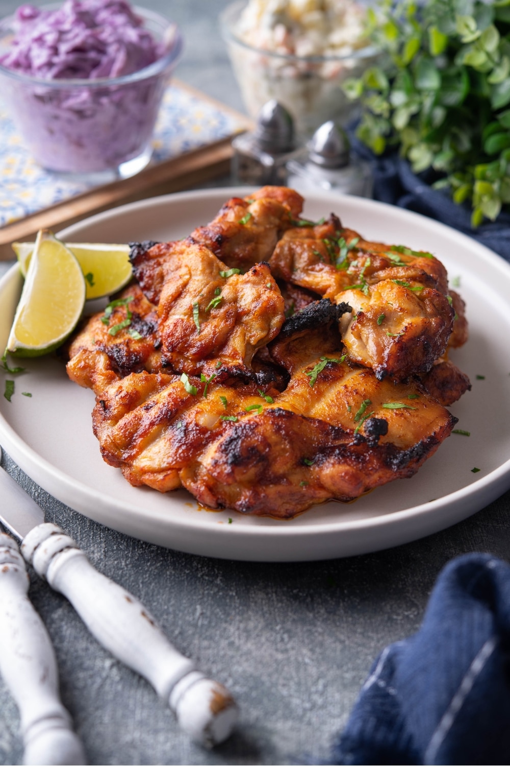 BBQ grilled chicken thighs on a white plate.