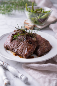 Two sirloin steaks on a white plate.