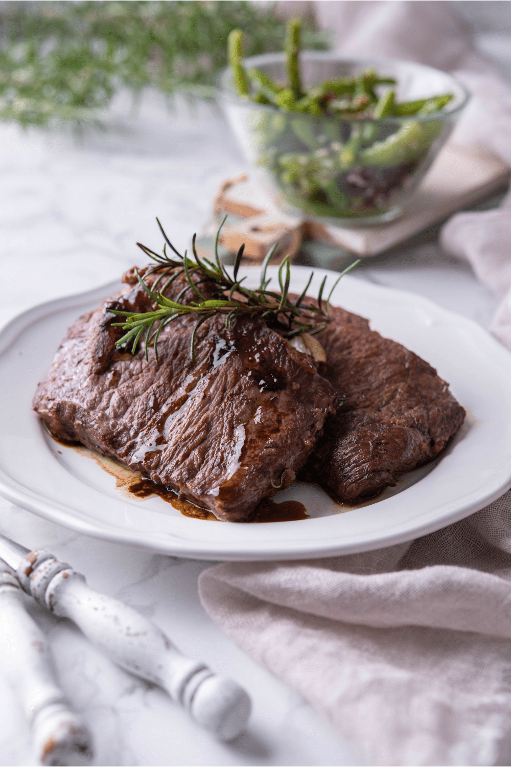 Two sirloin steaks on a white plate.