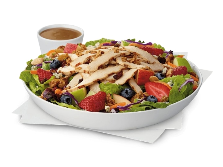 A chick fil a market salad with grilled chicken, berries, and lettuce.