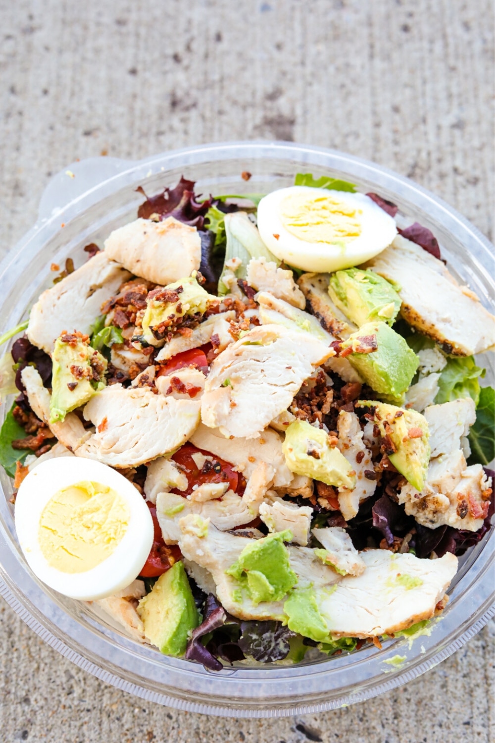 A Panera Bread green goddess salad in a circular plastic container.