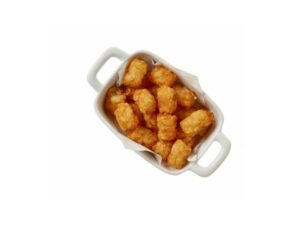 A bunch of tater tots in a white tray.