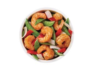 A bowl full of shrimp and vegetables.