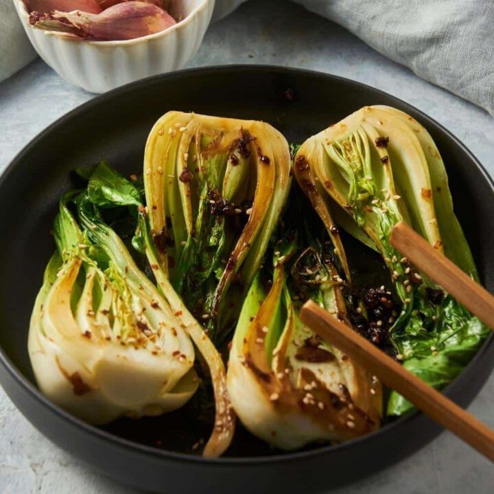 Four pieces of cooked bok choy in a skillet.
