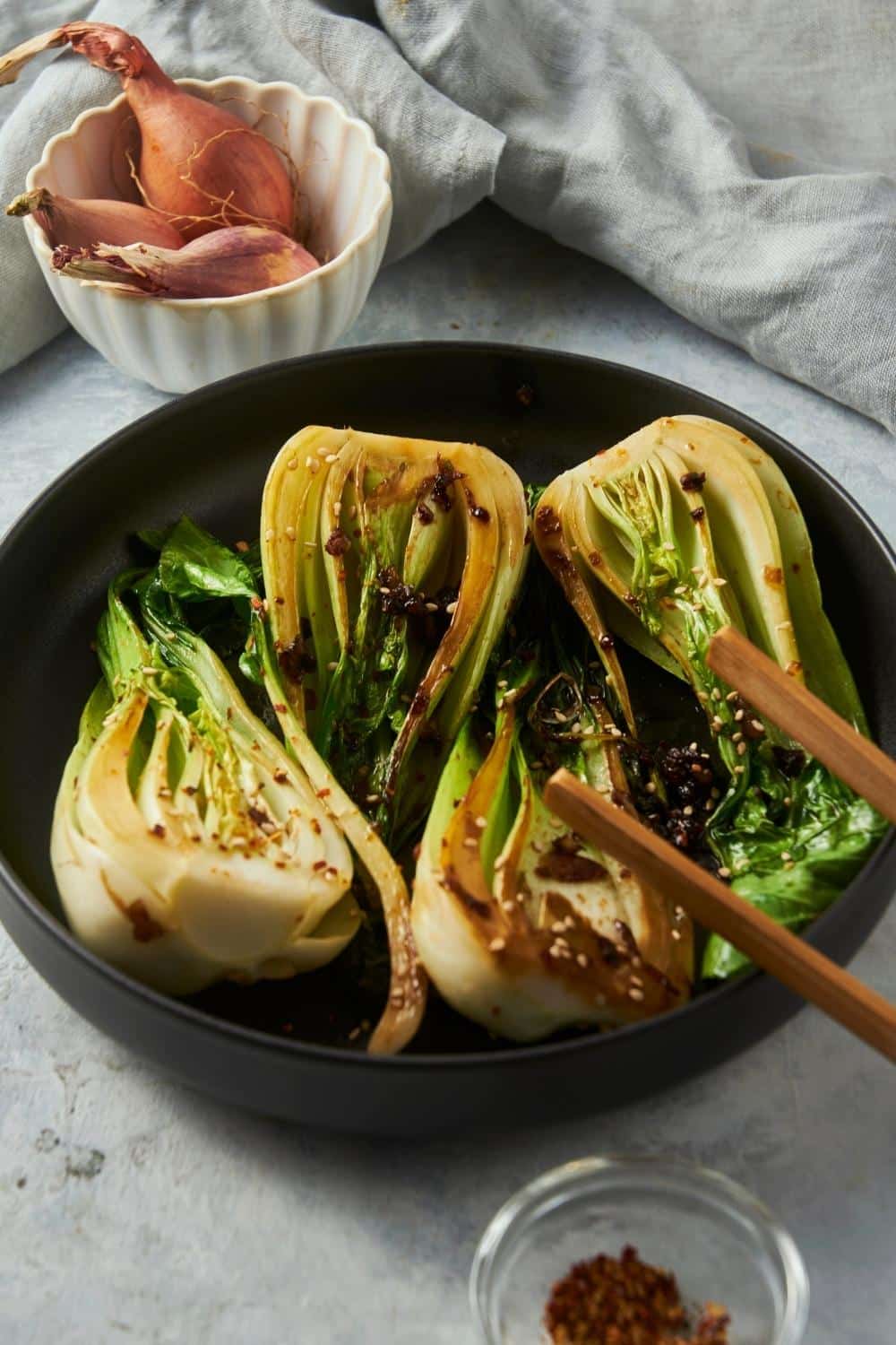 Four pieces of cooked bok choy in a skillet.