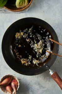 Minced garlic and shallots cooking in a skillet.