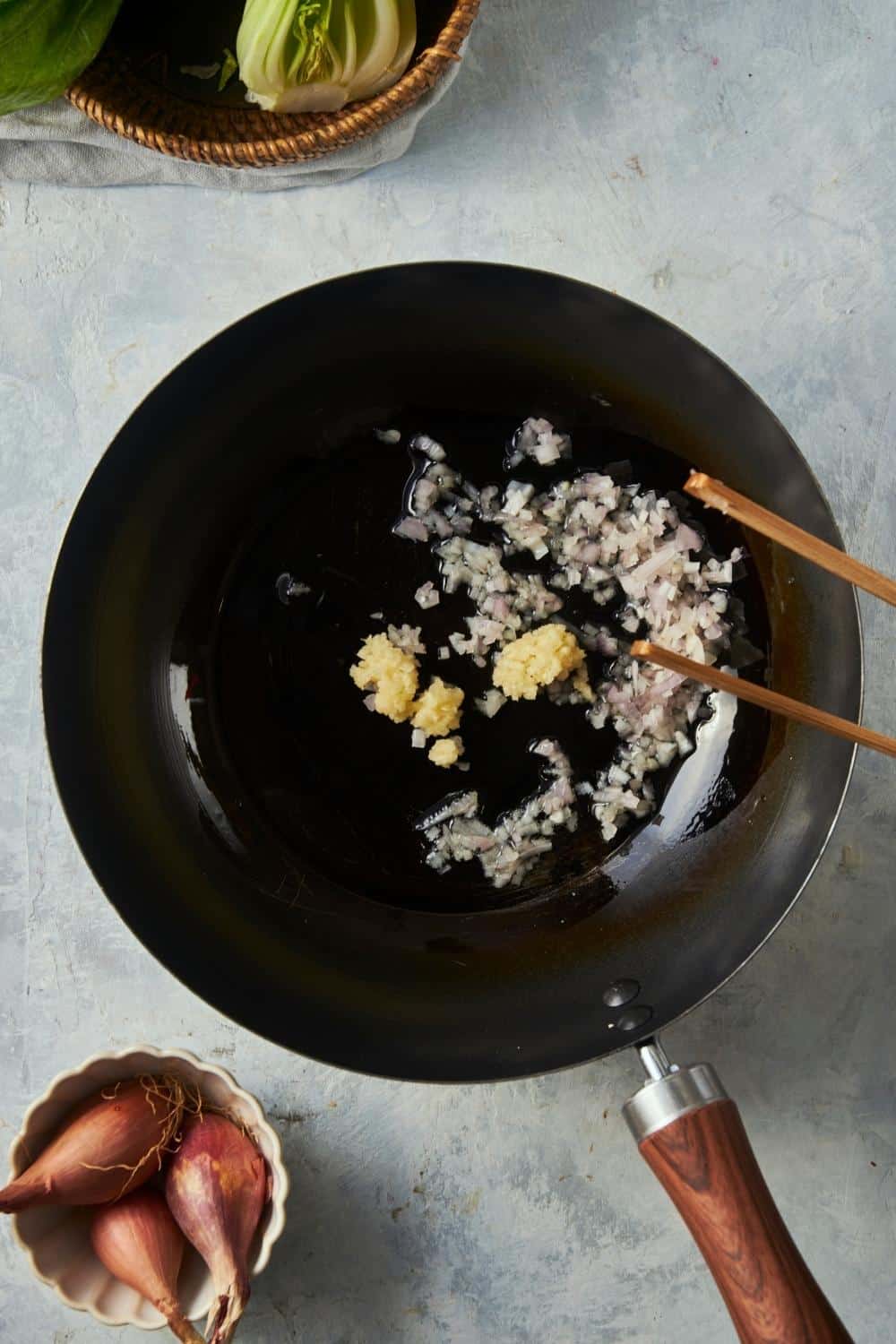 Garlic and minced shallots in a skillet with oil.