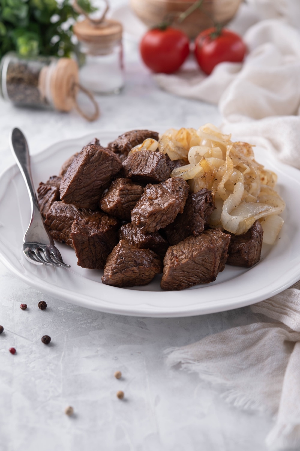 Seared steak tips on a plate with caramelized onions.